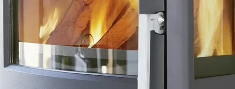 Close-up of flames behind the glass door of a wood-burning stove